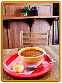 hot bowl of vegetable soup with a fresh-baked biscuit